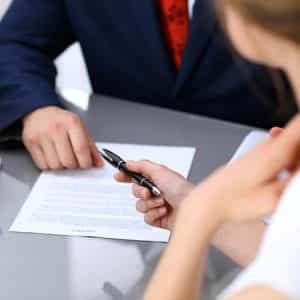 Business lady offering businessman black pen for signing a contract