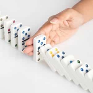 Dominoes Falling Stopped by Hand